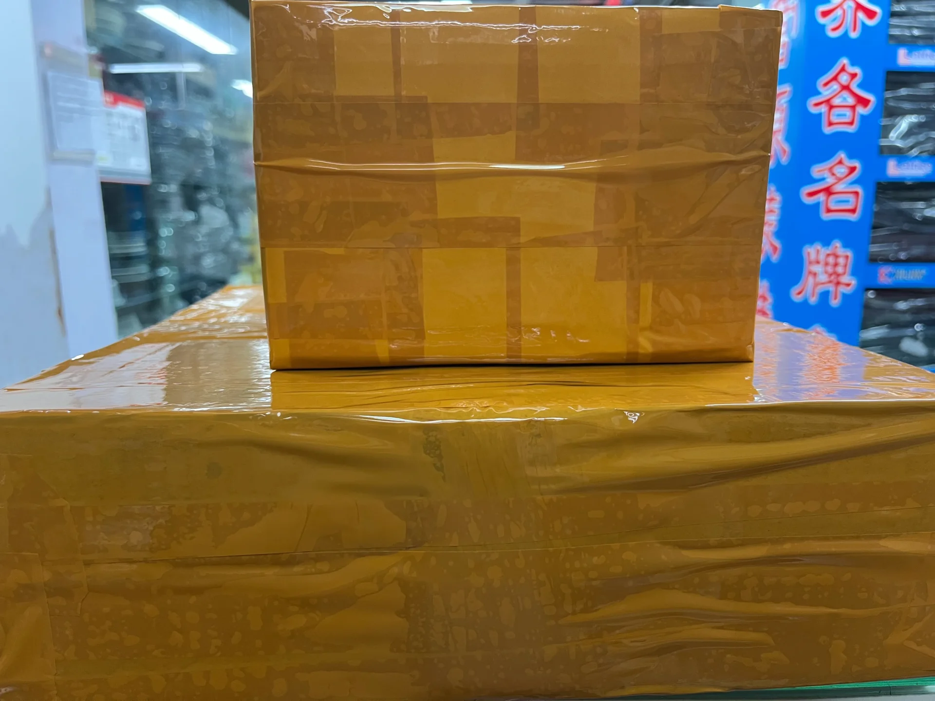 Sealed orange shipping parcels stacked at a Shenzhen Huaqiangbei electronics market for courier pickup